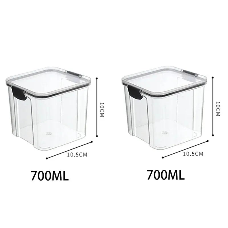 A collection of transparent storage containers filled with various dry foods like pasta, beans, nuts, and cereals on a wooden surface.