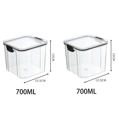 A collection of transparent storage containers filled with various dry foods like pasta, beans, nuts, and cereals on a wooden surface.